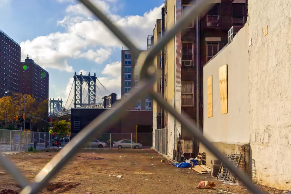 View of vacant lot in Manhattan through chain link fence